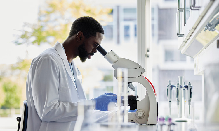 Stock image of man in lab with microscope
