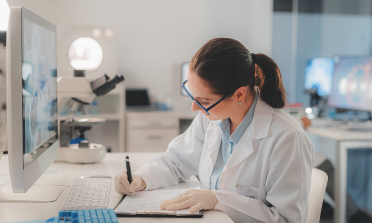 Researcher sitting in a lab writing