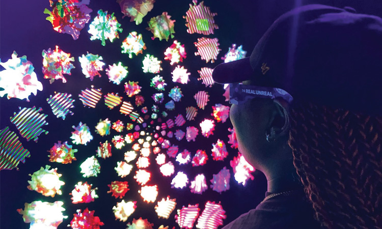 woman wearing chromadepth glasses looking at colorful display