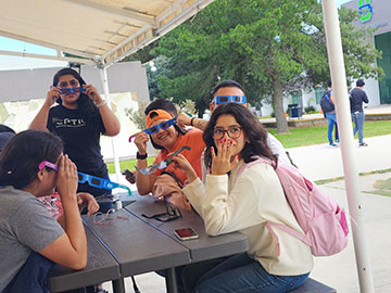 Ana Karen Reyes with students holding diffraction grating glasses