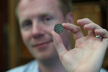 Researcher holds Byzantine silver coin