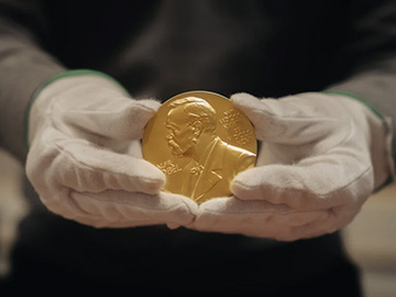 Nobel medal in gloved hands