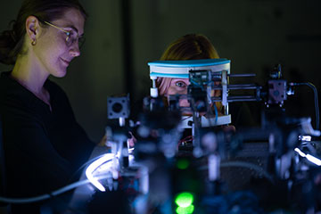 Woman performing vision test for two-photon vision on another woman