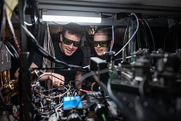 Researchers standing looking at a computer setup