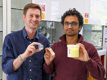 Researchers holding samples in containers