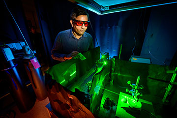 Man in lab with green laser light