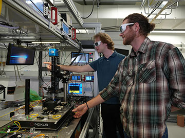 Researchers in a lab, pointing at a screen